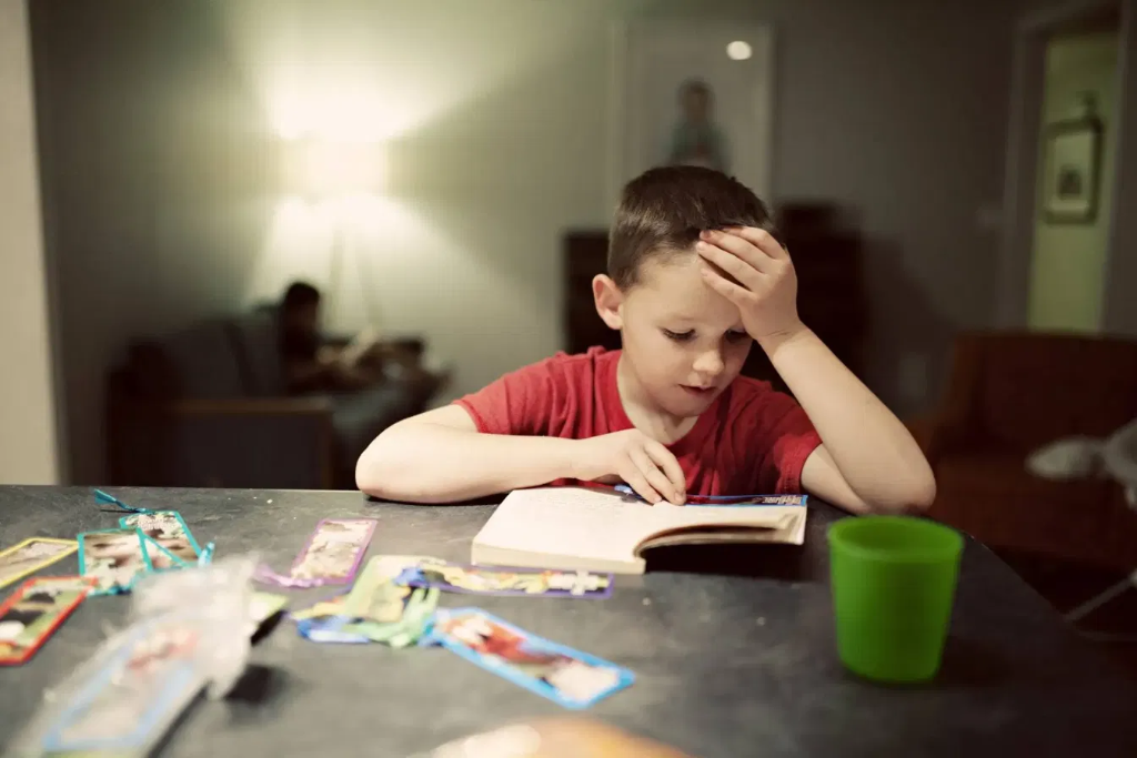 テーブルで本を読む男の子